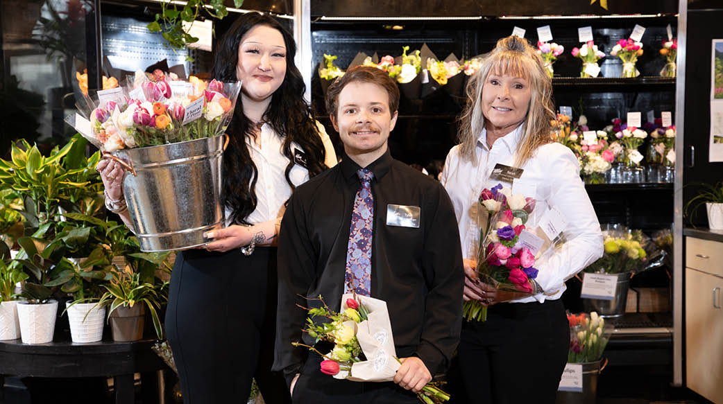 DLM Floral associates standing together with flowers