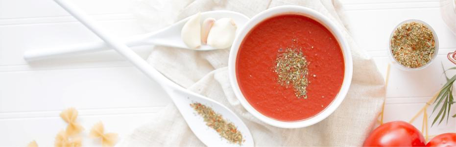 Bowl of tomato sauce with spices on top