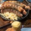 Cooked bratwurst with saurkraut and mustard and purple cabbage