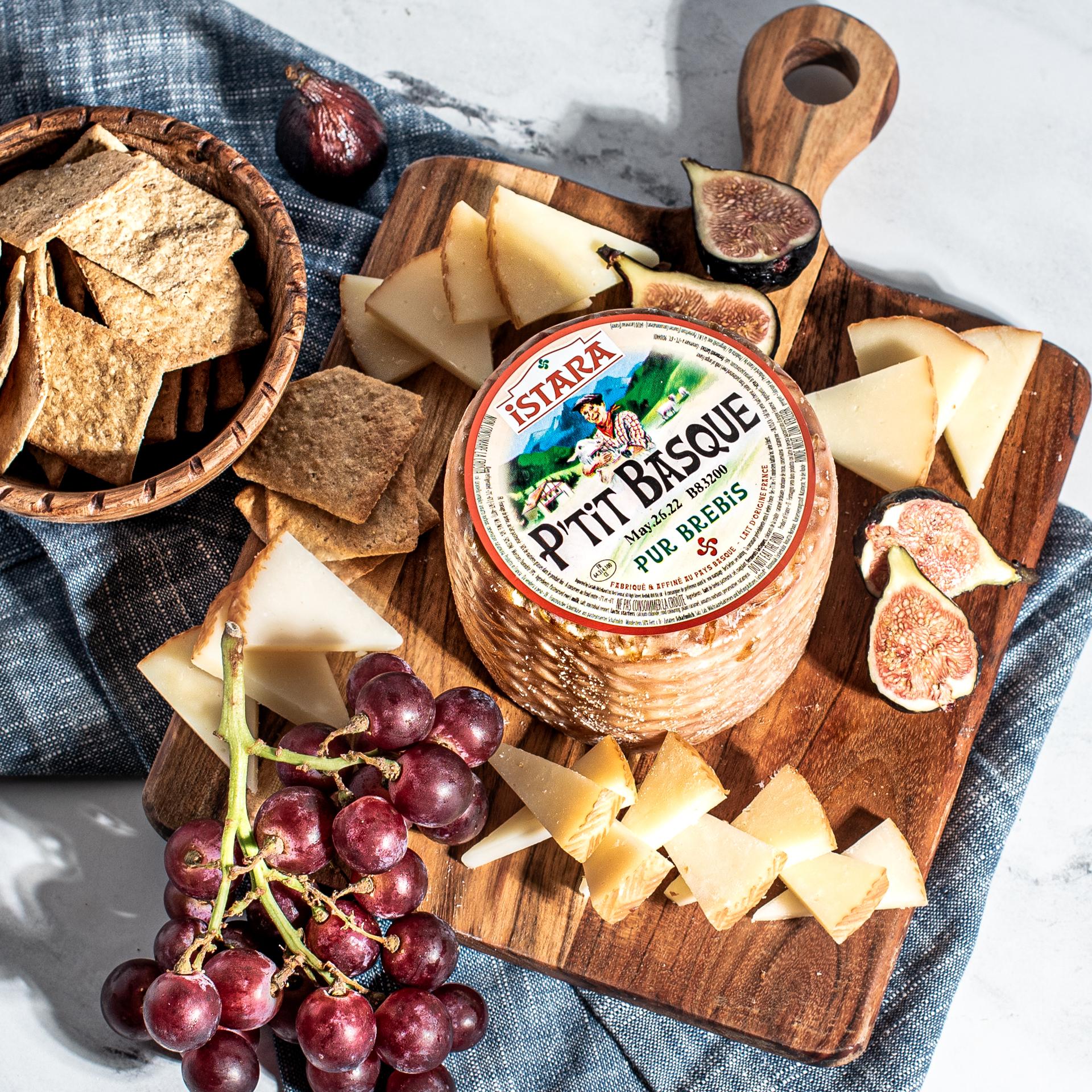P'tit Basque cheese served on a charcuterie board with crackers and fruit