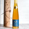 Savannah Bee Company Tupelo Gold Reserve Honey in a tall glass flute, golden-green honey from white tupelo blossoms