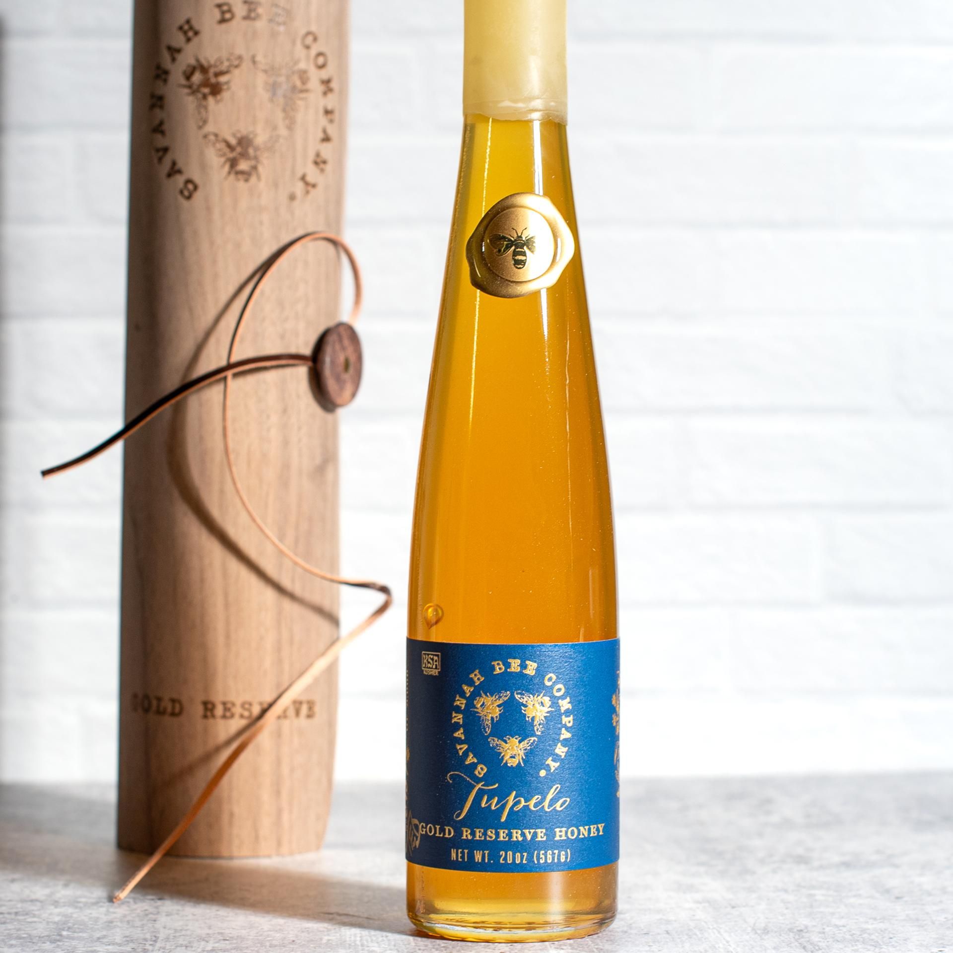 Savannah Bee Company Tupelo Gold Reserve Honey in a tall glass flute, golden-green honey from white tupelo blossoms